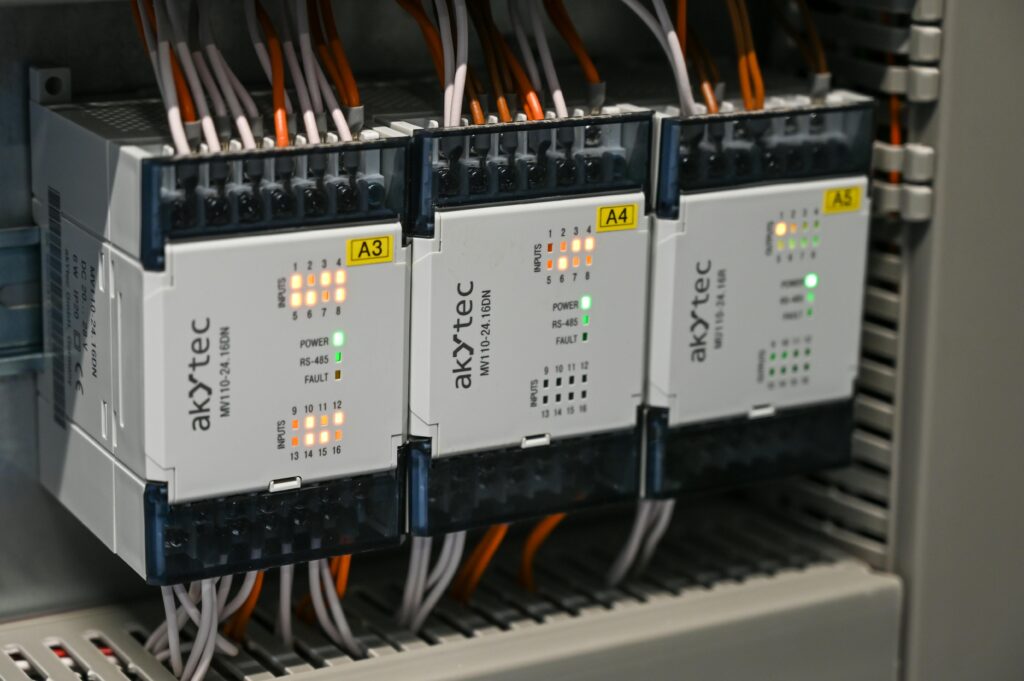 Close-up of industrial control boxes with wires and lights.